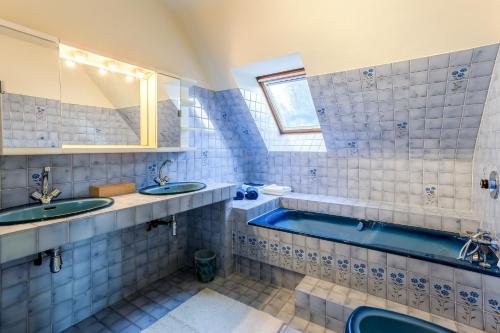 ein Badezimmer mit zwei Waschbecken und einer Badewanne in der Unterkunft Molinae in Saint-Juvat