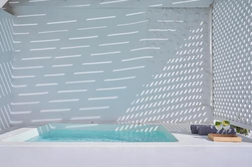 une baignoire avec une piscine d'eau en face d'un bâtiment dans l'établissement Mr and Mrs White Santorini, à Oia