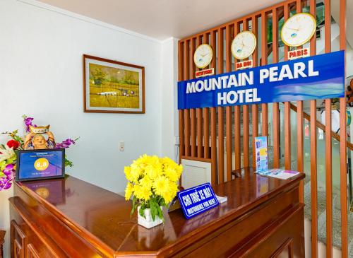 a hotel room with a desk with clocks on the wall at Mountain Pearl Hotel in Cat Ba
