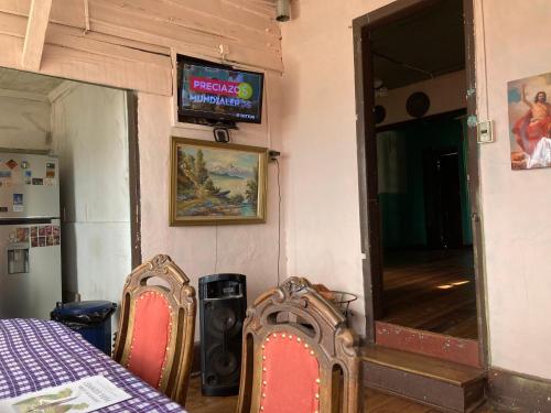 a room with a table and two chairs and a television at Hostal brons in Valparaíso