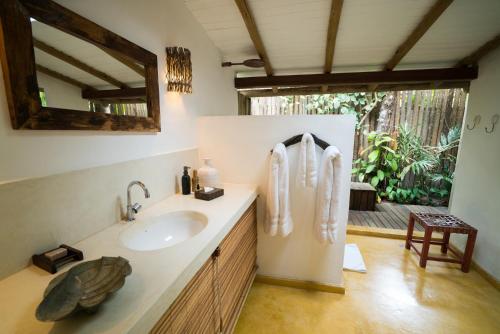 un baño con lavabo y espejo en UXUA Alma, en Trancoso