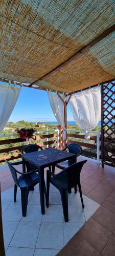 een tafel en stoelen op een patio met uitzicht op de oceaan bij La Collina del Riccio in Ortona