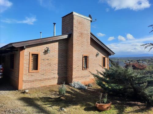 un pequeño edificio de ladrillo en la cima de una colina en MiraSierras -casas vacacionales- en Villa General Belgrano