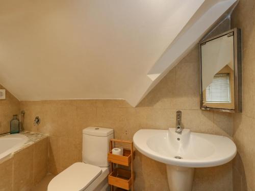 uma casa de banho com um lavatório, um WC e um espelho. em Winterslow em Weymouth