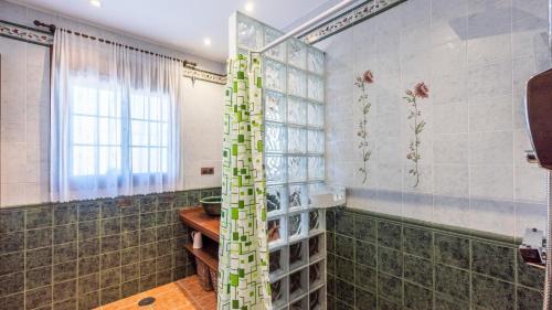 baño con paredes de azulejos verdes y ducha. en Casa Cuatro Vientos Almogía by Ruralidays, en Almogía