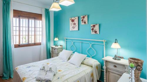 una camera da letto con pareti blu e un letto con cuscini di Casa Cuatro Vientos Almogía by Ruralidays ad Almogía