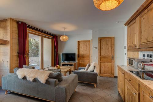 een woonkamer met 2 banken en een tv bij Apartment le Paradis 1 - Alpes Travel - Central Chamonix (sleeps 4) in Chamonix-Mont-Blanc