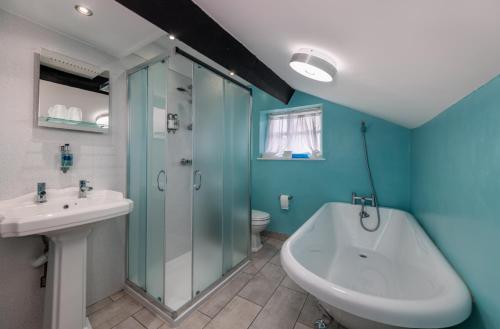 a bathroom with a shower and a sink and a tub at Bower House Inn in Eskdale