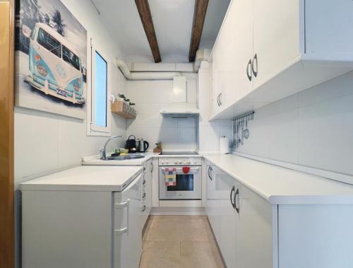 una cocina blanca con encimeras blancas y armarios blancos en Stay U-nique Apartments Murillo, en Barcelona