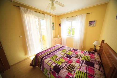 托雷維耶哈的住宿－Holiday home Punta Prima，一间卧室配有一张带五颜六色被子的床