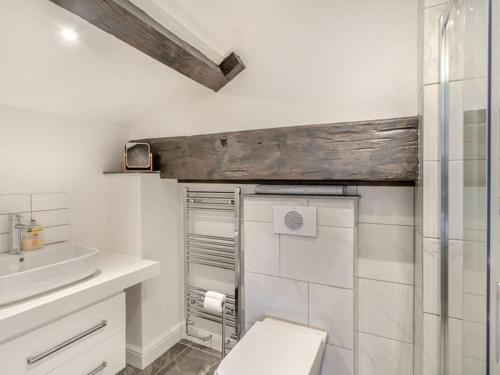 Baño blanco con aseo y lavamanos en The Cottages at Ivy Farm by Charles Alexander Short Stay, en Lytham St Annes