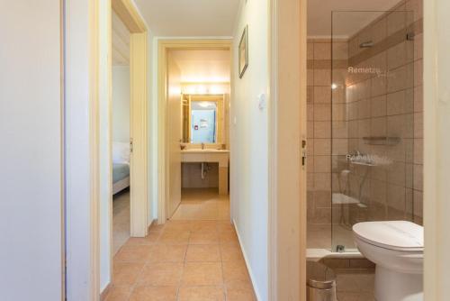 a bathroom with a toilet and a sink and a mirror at Nafsika Beach House in Dhamoulianáta