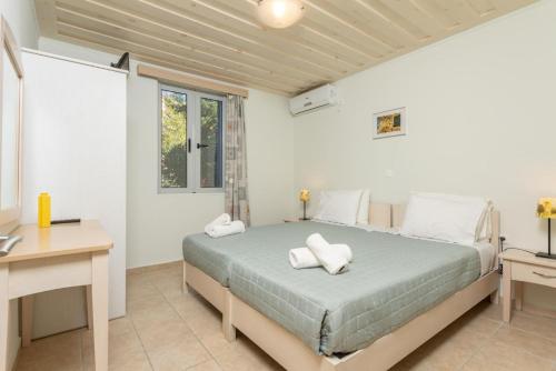 a bedroom with a bed with two pillows on it at Nafsika Beach House in Dhamoulianáta
