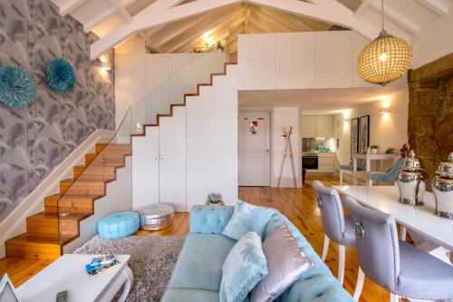 - un salon avec un canapé bleu et un escalier dans l'établissement Oporto Platinum Loft, à Porto