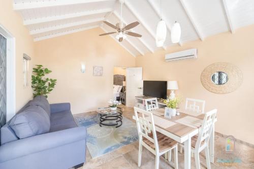 a living room with a table and a blue couch at Dover Court Apartments - Steps to St Lawrence Gap in Christ Church