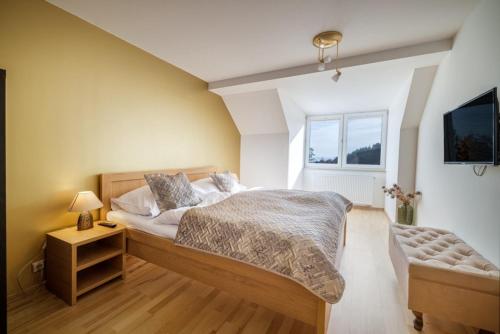 a bedroom with a large bed and a window at Apartmán ZORA Family in Tatranská Lomnica
