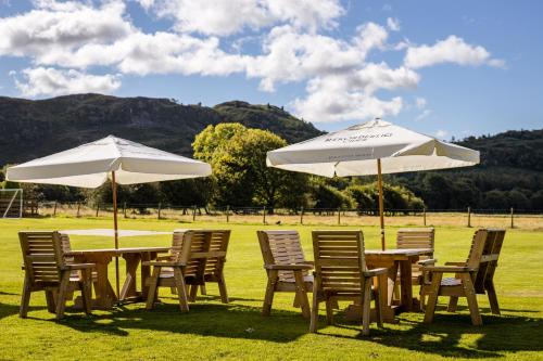 a group of tables and chairs with umbrellas at Bower House Inn in Eskdale