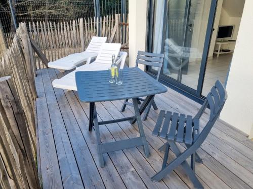 a blue table and chairs on a deck at A 200m de la plage - L'Océan - in Mimizan-Plage