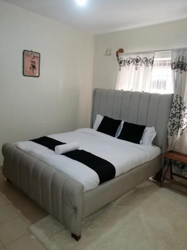 a bed in a room with a large bed withskirtspectspectspects at Nash Issah Studio10 - 1bedroom in Nakuru
