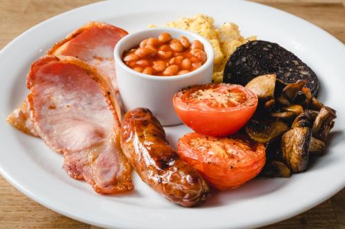 a plate of food with meat and vegetables on a table at Bower House Inn in Eskdale