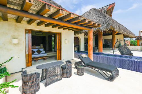 a patio with chairs and tables on a house at Beautiful Family House Beachfront in La Unión