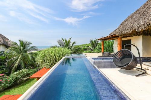 a swimming pool in front of a villa at Beautiful Family House Beachfront 