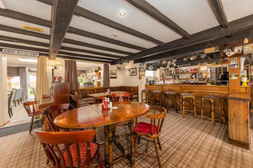 a restaurant with tables and chairs and a bar at Bower House Inn in Eskdale