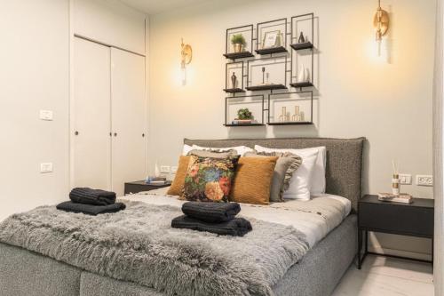 um quarto com uma cama com almofadas em Renovated 2 BR with 2 BTH front Mamilla Mall em Jerusalém