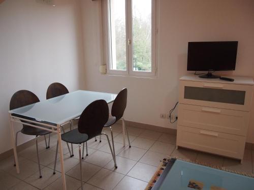 un salon avec une table, des chaises et une télévision dans l'établissement L'Escale 80, à Amiens