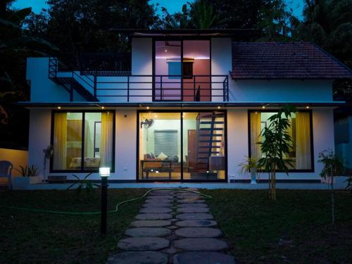 a house at night with the lights on at Eva Meadows in Kollam