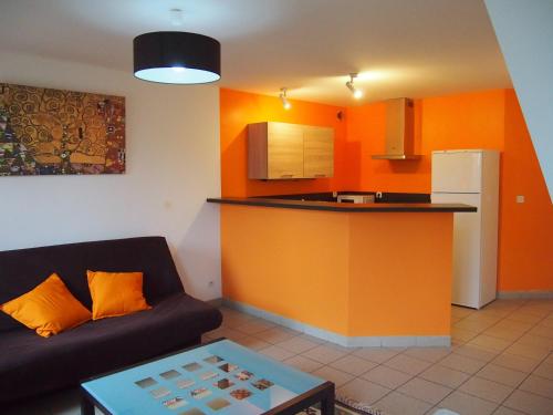 a living room with a couch and a kitchen at L'Escale 80 in Amiens