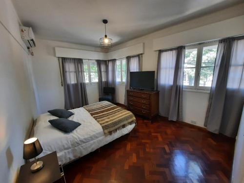 sypialnia z łóżkiem i telewizorem z płaskim ekranem w obiekcie Departamento Mendoza w mieście Mendoza