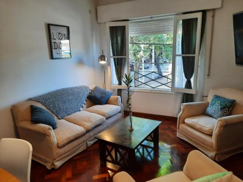 sala de estar con sofá, 2 sillas y mesa en Departamento Mendoza en Mendoza