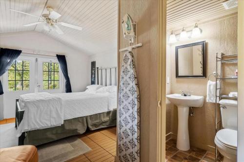 um quarto com uma cama, um lavatório e um WC em Four Winds Victorian Venue & Suites em Bonham