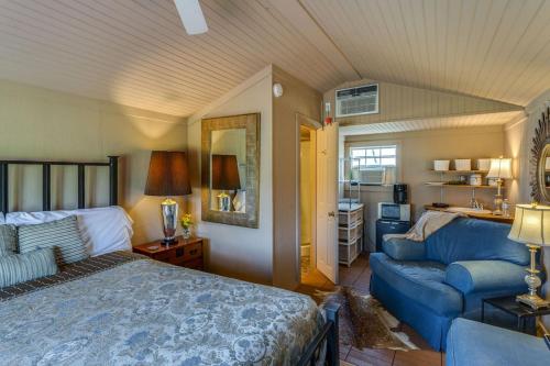 um quarto com uma cama e um sofá azul em Four Winds Victorian Venue & Suites em Bonham