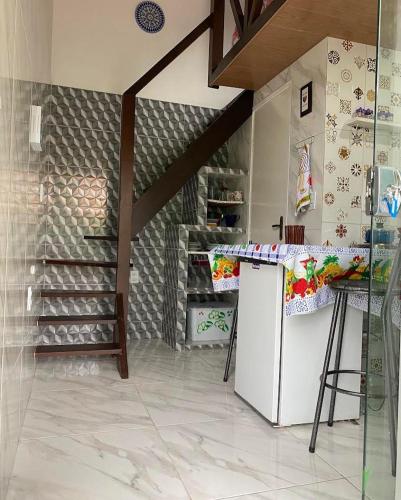 uma cozinha com um balcão e uma escada em Micro casa com vista para o Morrão - Vale do Capão em Vale do Capão