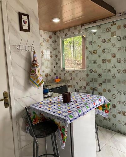 una pequeña cocina con mesa en una habitación en Micro casa com vista para o Morrão - Vale do Capão en Vale do Capao