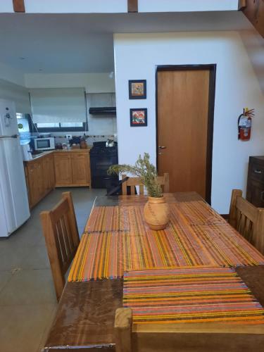 una cocina con una mesa con una maceta. en MiraSierras -casas vacacionales- en Villa General Belgrano