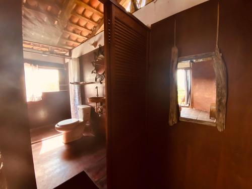 a bathroom with a toilet and a window at Casa Sakal in Puerto Ángel