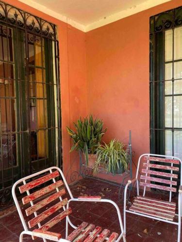 two benches sitting in front of a wall with plants at Casa de campo “Los Ombues” in Suipacha