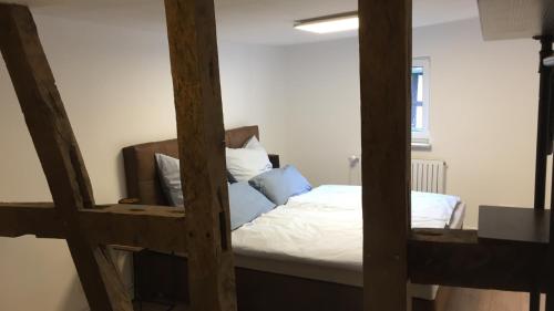 1 dormitorio con 1 cama con sábanas blancas y almohadas azules en Bauernhaus zwischen Rheingau und dem Taunus, en Schlangenbad