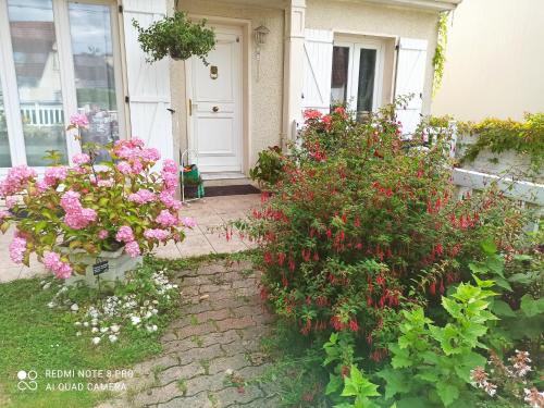 Chambre d hôte à 20 min de VERSAILLES في Le Mesnil-Saint-Denis: حفنة من الزهور أمام منزل