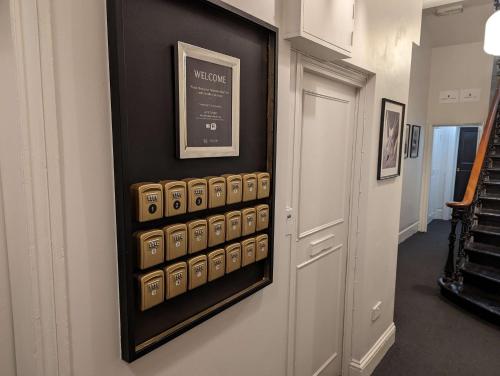 a room with a wall with a display of dominoes at London Collection - Bayswater in London