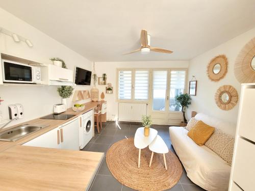 eine Küche und ein Wohnzimmer mit einem Sofa und einem Tisch in der Unterkunft Studio 24m² Montpellier - Hôpitaux facultés Centre in Montpellier