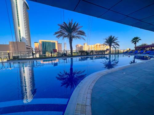 a swimming pool with palm trees and a city skyline at Exquisite, luxe 1BD Apartment, Unparalleled Sea Views, Prime Dubai Marina Location & Full Kitchen by "La Buena Vida Holiday Homes in Dubai