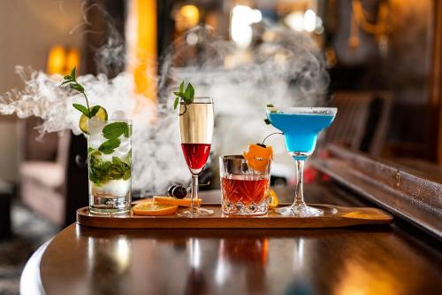 a tray with four different cocktails on a table at Duisdale House Hotel in Isleornsay