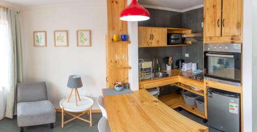 a kitchen with a counter and a table in a room at Natagonia Apartments in Puerto Natales