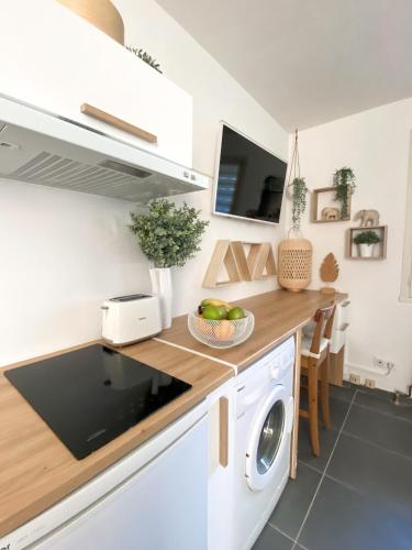 une cuisine avec un lave-linge et un sèche-linge sur un comptoir dans l'établissement Studio 24m² Montpellier - Hôpitaux facultés Centre, à Montpellier