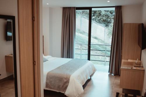 卡利的住宿－Antope - Apartaestudios，一间卧室设有一张床和一个大窗户