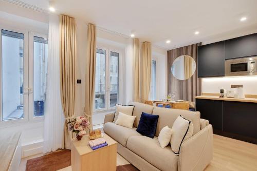 Il comprend un salon avec un canapé et une cuisine. dans l'établissement RESIDENCE Pelican - Louvre, à Paris